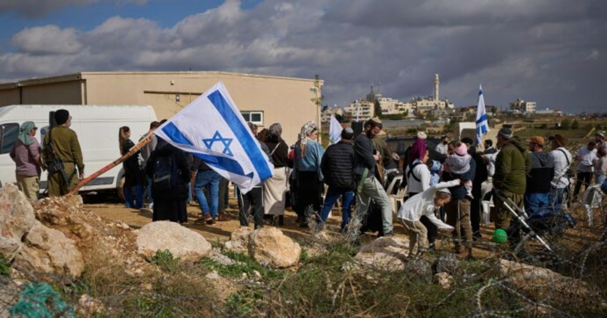 diplomatici europei aggrediti a Taybeh, coloni israeliani con le bandiere in un avamposto in Cisgiordania