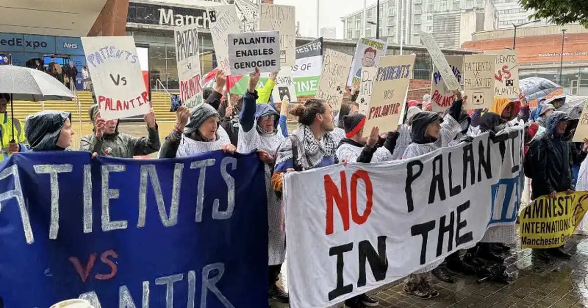 Palantir NHS, protesta a Manchester durante NHS ConfedExpo con i cartelli Patients vs Palantir