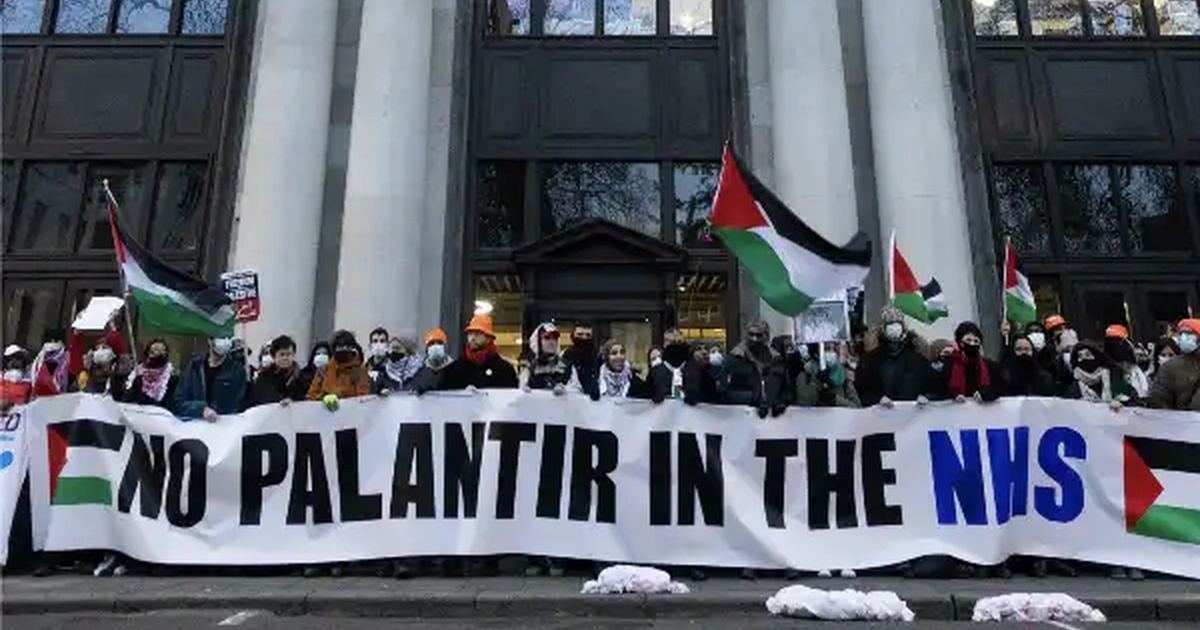 Palantir NHS, operatori sanitari bloccano la sede di NHS England a Londra con lo striscione No Palantir in the NHS